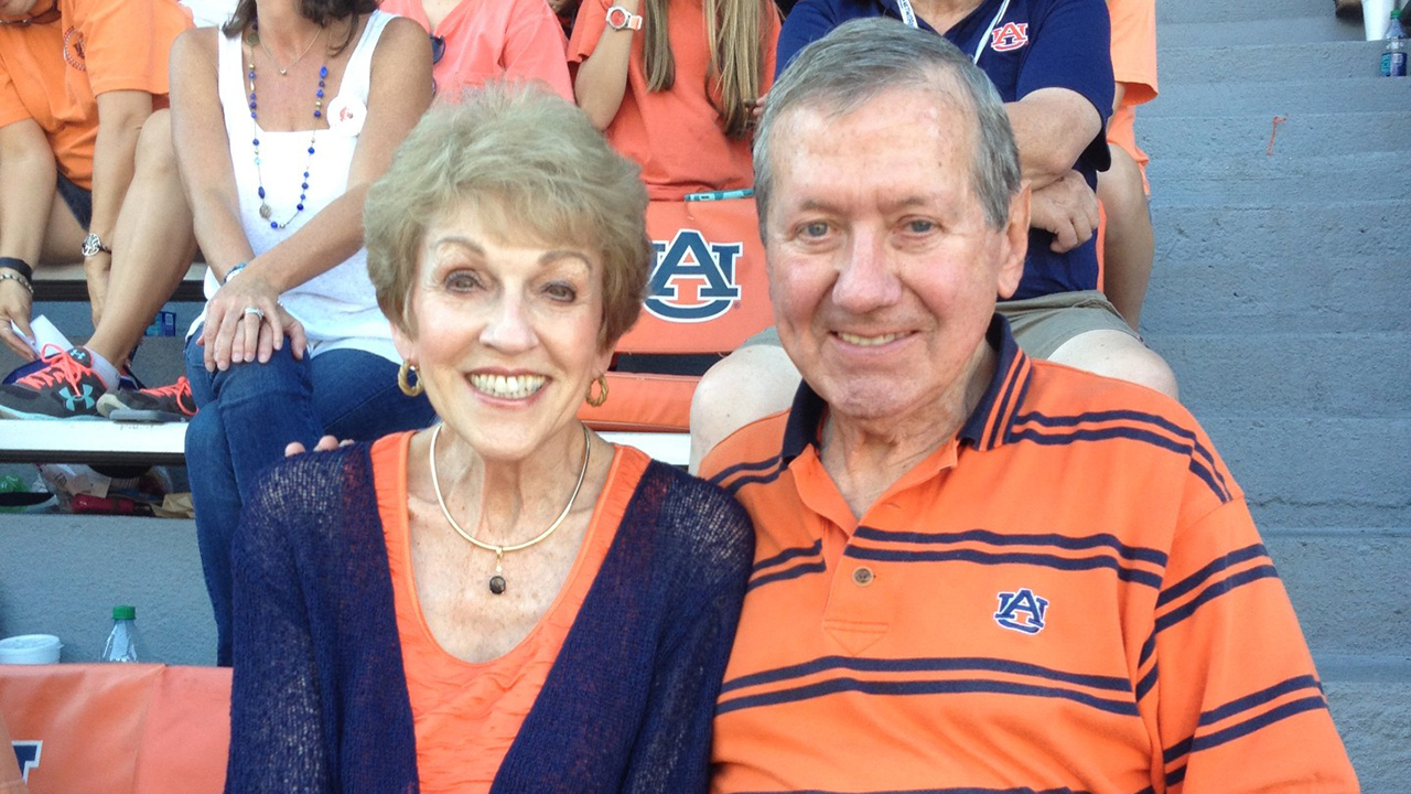 Wearing orange and blue Auburn colors, Phil and Frances Herron are pictured at an Auburn football game.