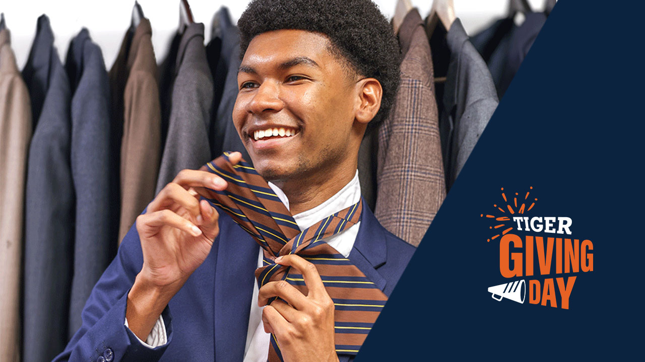 Student putting on tie at the Campus Career Closet. 