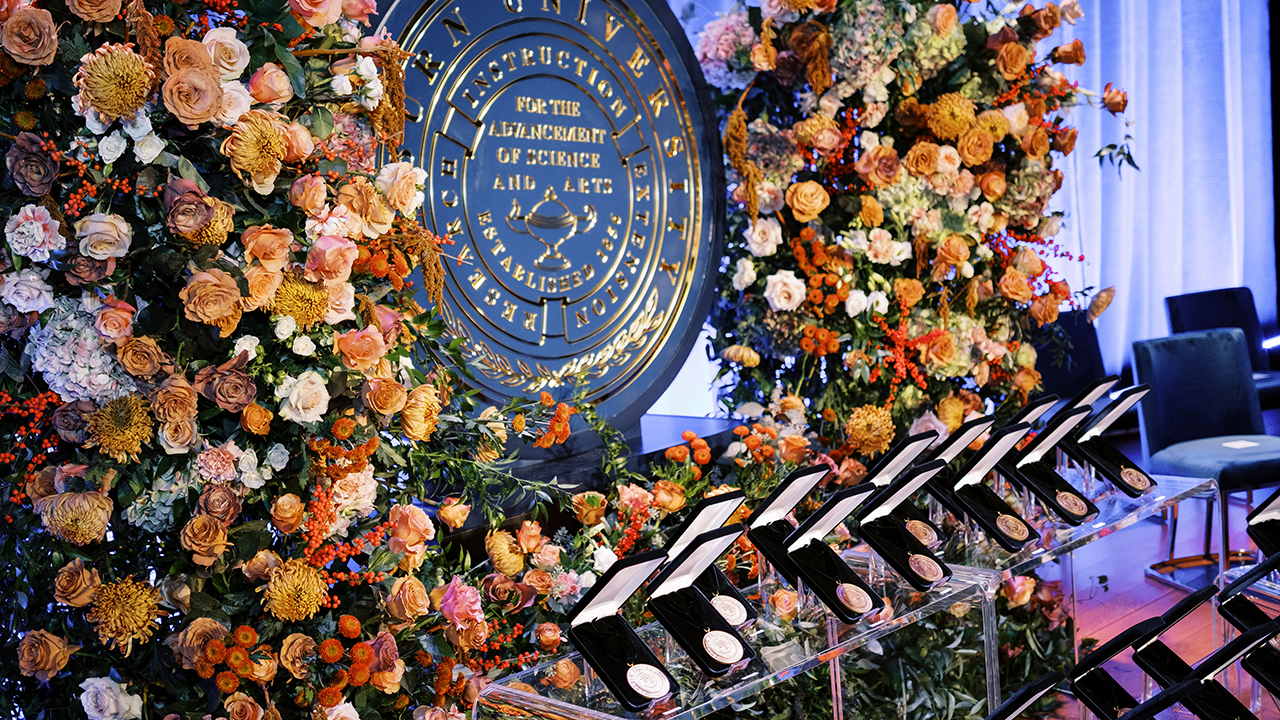 Floral arrangements surrounding the Auburn University Seal and awards medals
