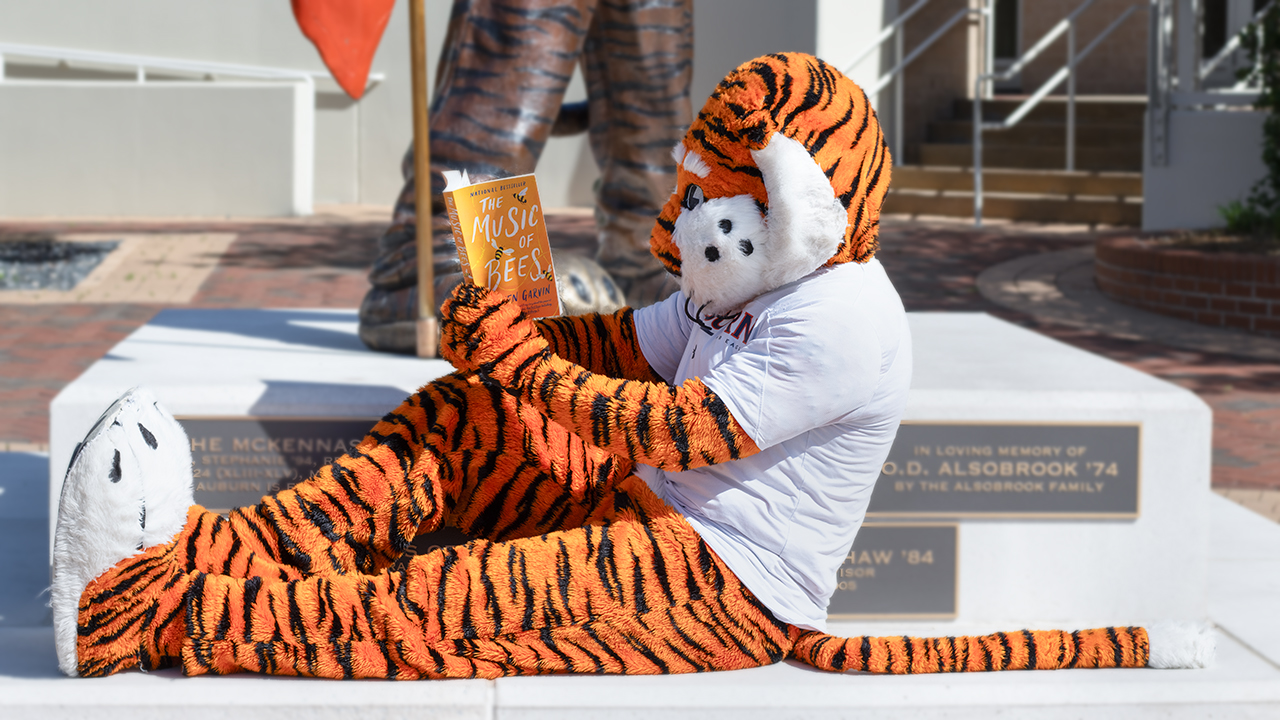 Aubie lounges while reading The Music of Bees